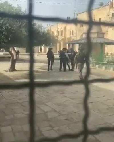 Israeli police brutally beating a Palestinian man in the courtyards of Al-Aqsa mosque