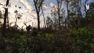 A Ukrainian Micro recon drone spots two russian soldiers hiding in conceilment, their position is relayed to Ukrainian infantry who saturate the area with MG fire, killing the russians. October 2025.