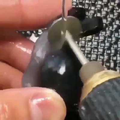 Snail figure being carved out of a stone.