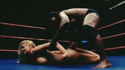 A big breasted, blonde bimbo submits to a much larger woman…