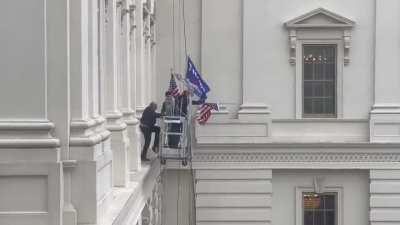 Trump supporters taking down the American flag at the Capitol to put up a trump flag.