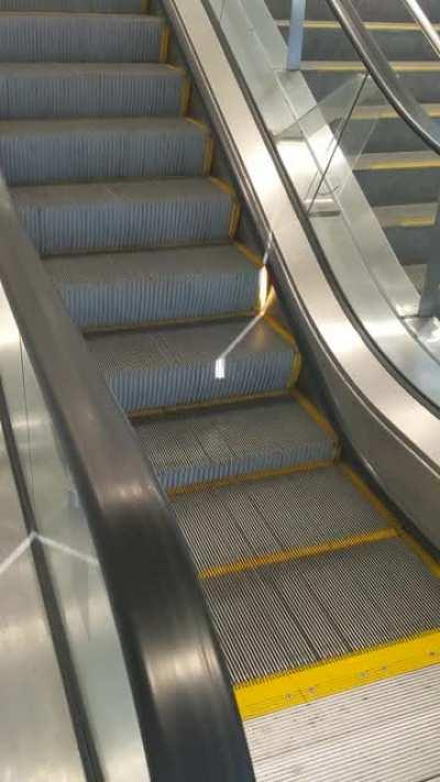 This beam of light snaking its way down an escalator.