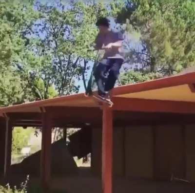 Boy gets a surprise uppercut from his scooter as rides off the roof of a building
