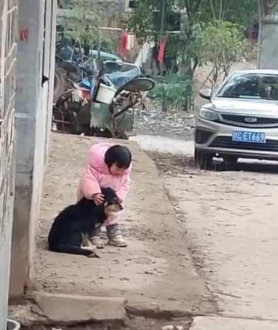 This little girl covers her dog's ears, so he won't be afraid of fireworks
