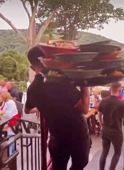 Elite waiter with a shoulder as mighty as his balance
