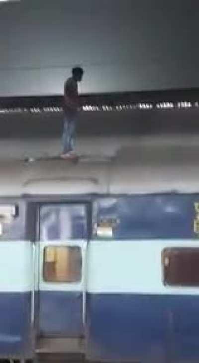 Man grabbing cables over a train. EXPLICIT.