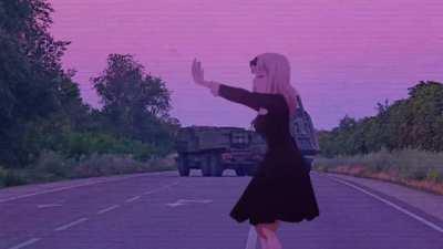 What is the name of the song?, Chika dancing in the foreground. Ukrainian Artillery systems in the background.