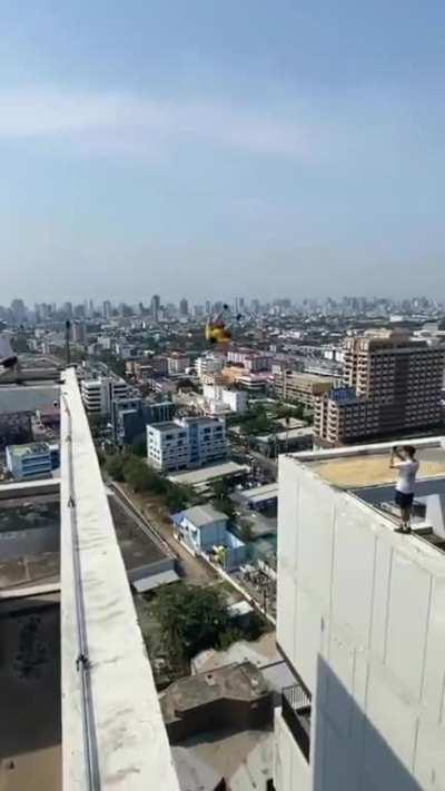 Showcasing parkour skills by jumping from the height of one roof to another..