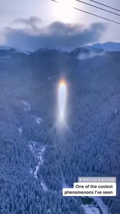 This is a parhelion, a bright spot in the sky appearing on either side of the sun, formed by refraction of sunlight through ice crystals high in the earth's atmosphere.