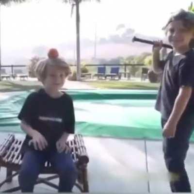 Two kids playing with a baseball bat