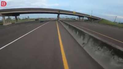 Erratic truck driver clips rider on the highway.