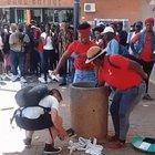 Man tries to clean up litter thrown on the sidewalk by a group of women. They had other ideas