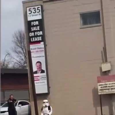 Stormtrooper waving fake gun at traffic