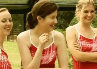 Female swim instructor pulls down the swimsuit of a male student with female students watching.