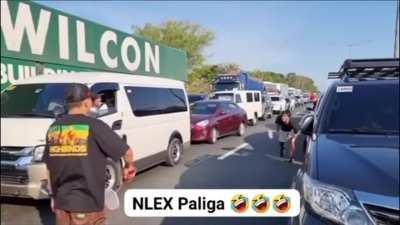 Due to slow heavy traffic, motorists play badminton to pass the time