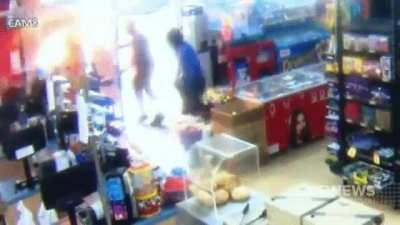 Store clerk using flame thrower to fight off robbers.