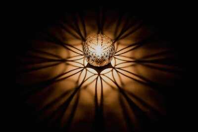 A candle holder which creates a warping geometric projection as it burns