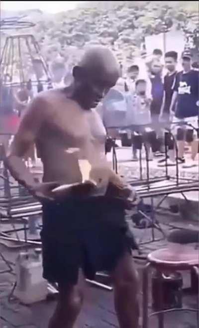 Guy puts burning piece of wood down front of his pants.