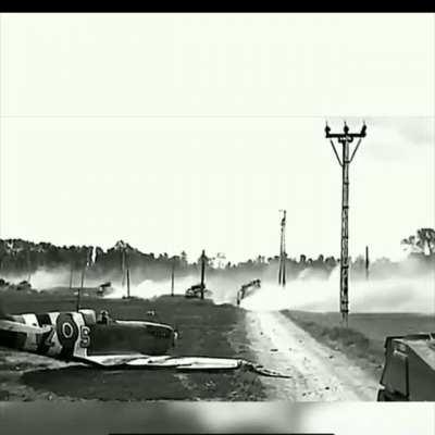 British armor passing a downed Canadian fighter in France