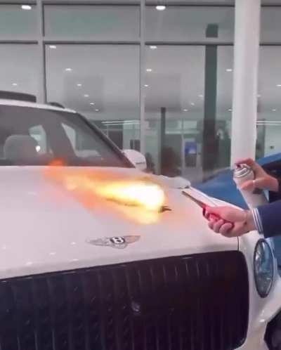 Bentley staff spray paint and flame one of their cars to show how their paint protection product works.