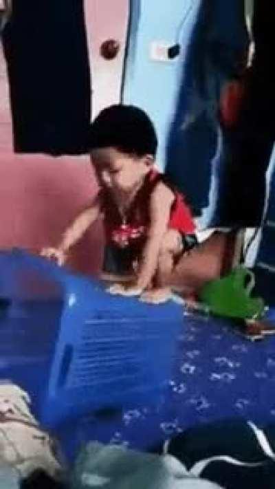 Kid tries to pin the hamper