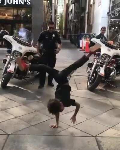 A policeman beats an unarmed black child in public in front of a cheering crowd