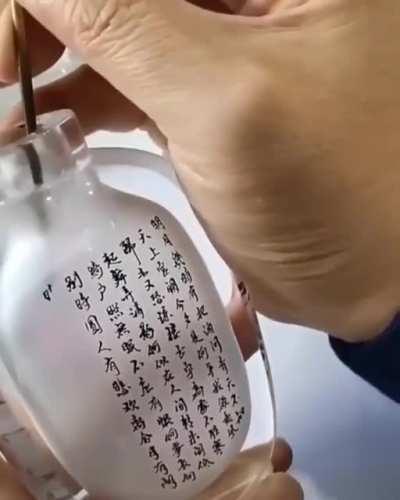 Calligraphy on the inside of a glass container