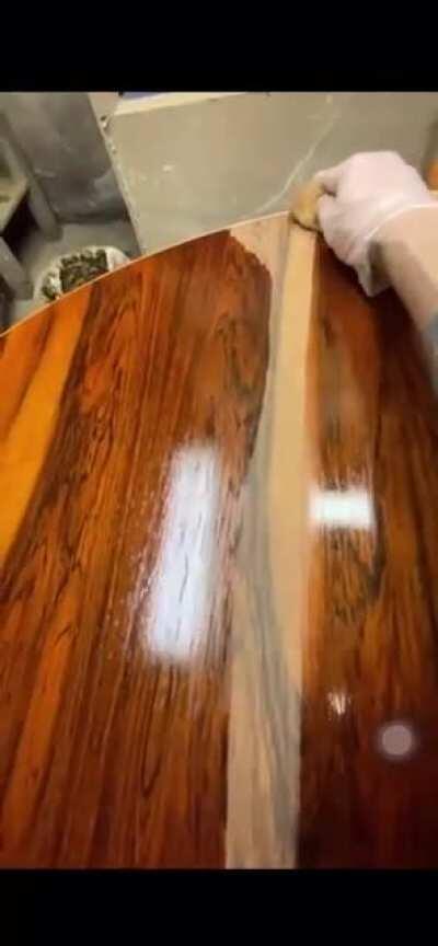 Applying oil to a rosewood table.