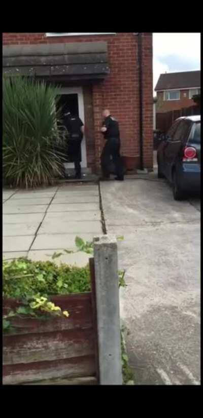 British Police knock down guys door, he escapes through the top floor window.