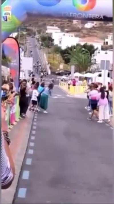 Stepping in front of a racing bicyclist at the finish line