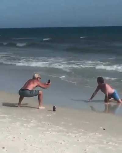 Dads imitating their daughters on the beach