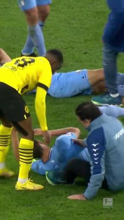 A footballer pretending to be injured gets taken out by the medic who came sliding in