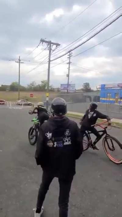 Kid does a wheelie on a dirt bike