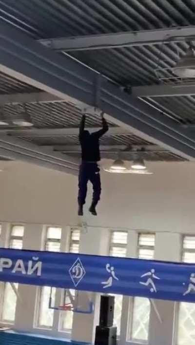 Scaffolding falls from under the worker while preparing a hall for an event. He hangs onto the ceiling until the people underneath can rig something to break his fall. There were no reported injuries.