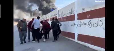 ITV News UK interviews a man in a group waving a white flag at Israeli forces in Gaza. Once the interview is finished, an Israeli sniper shoots him dead. The live reporting captures the moment of shooting of the interviewee