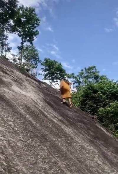 How this monk is able to climb this mountain side without using a rope