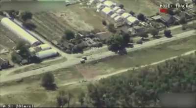 A Ukrainian drone is filming two Russian UAZ Buchankas speeding down a road to not get hit by an FPV drone, which leads to the two vehicles colliding and flipping over.