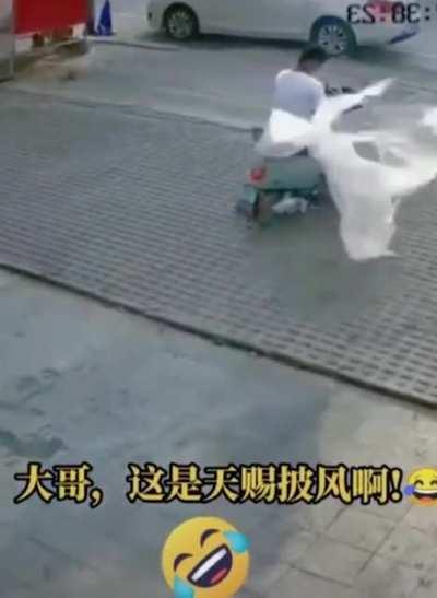 A wayward plastic sheet cloaks a rider.