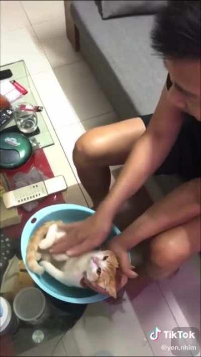 Dad teaches son how to bathe a baby, featuring a very obliging volunteer.