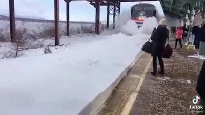 The train arrives on a snowy day