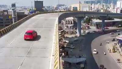 Speeding idiot losses control of car on a flyover, falls right down
