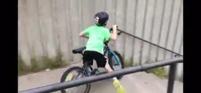 Kid tries to ride his bike down a long set of steps and yells 