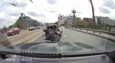 very careless biker rear ends car on a bridge