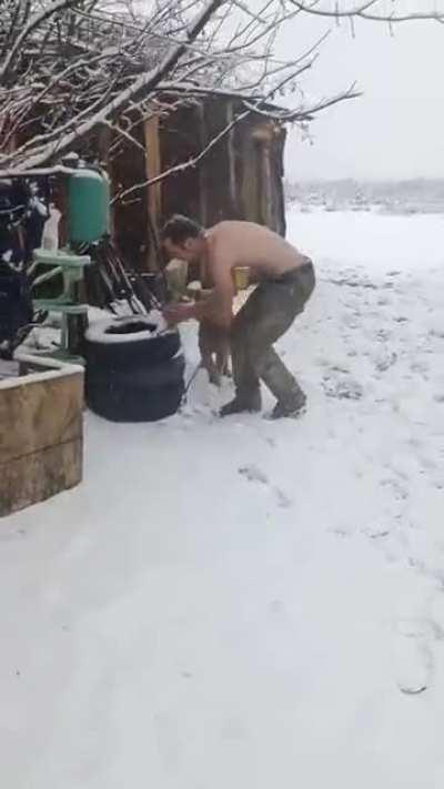 Two soldiers and a dog having fun in the snow.