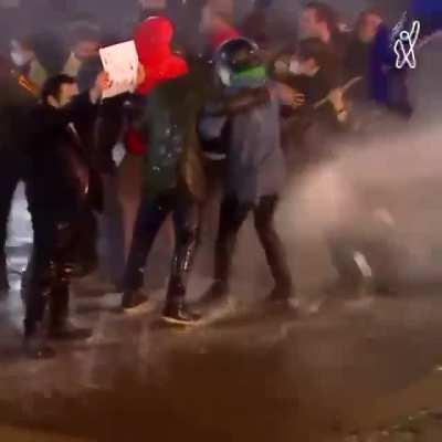 A woman near the Georgian parliament bravely goes to special forces with the flag of the European Union despite the work of the water cannon