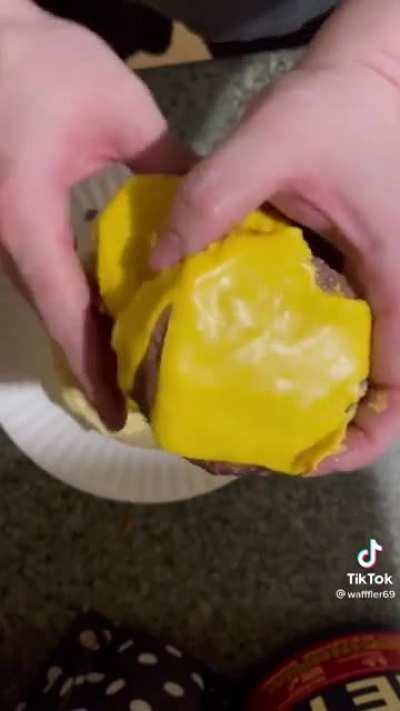 Shakey, sweaty man eats a fly riddled monstrosity that he calls a burger.