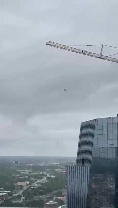 A man suspends himself off a crane atop a skyscraper and then does this…
