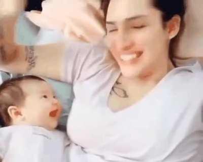 Baby smiles at mom as she takes her glasses off