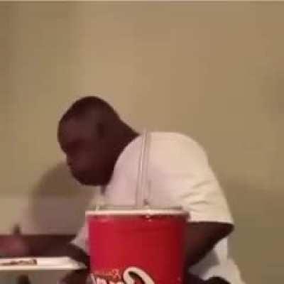 Just a guy enjoying his chicken, with a side of Coke...