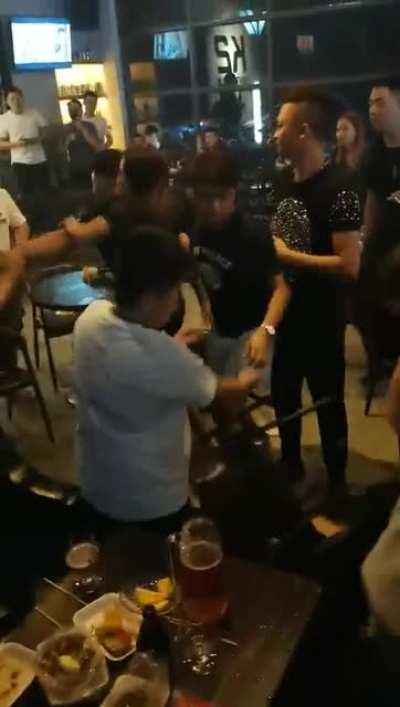 Young Chinese people brawling in a restaurant.